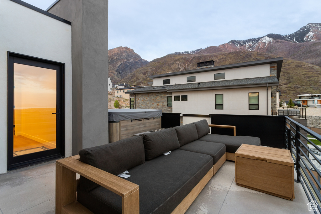 Balcony featuring a hot tub, an outdoor living space, and a mountain view