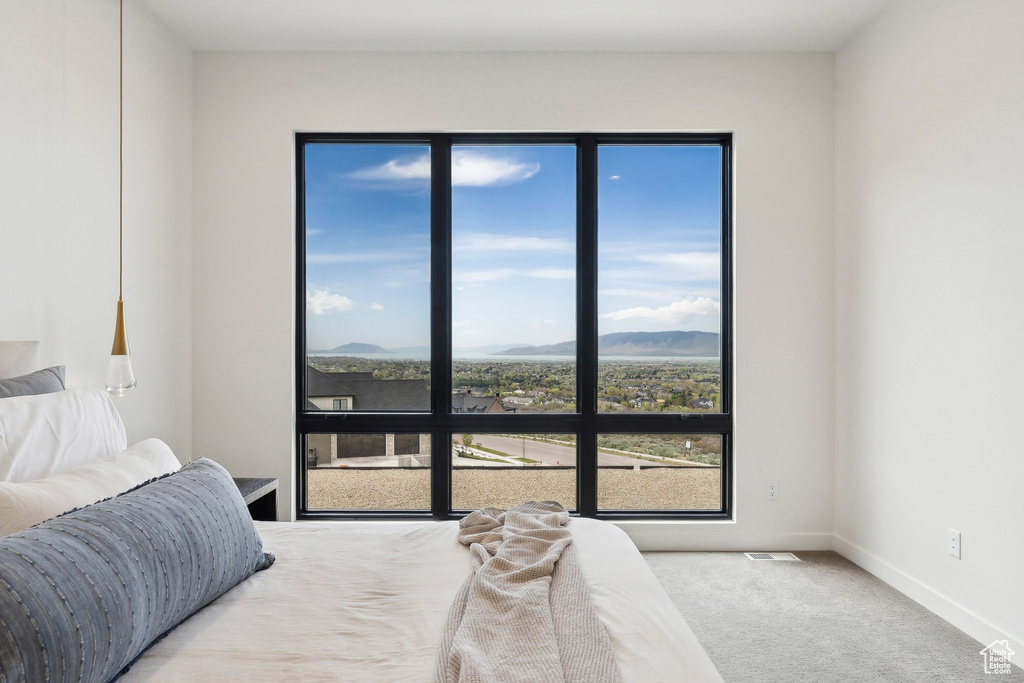Carpeted bedroom with baseboards, a mountain view, and visible vents
