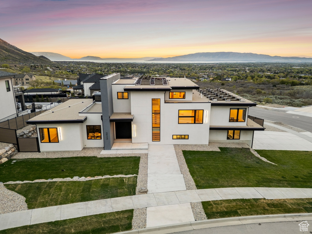 View of front of house featuring stucco siding, a front lawn, and a mountain view