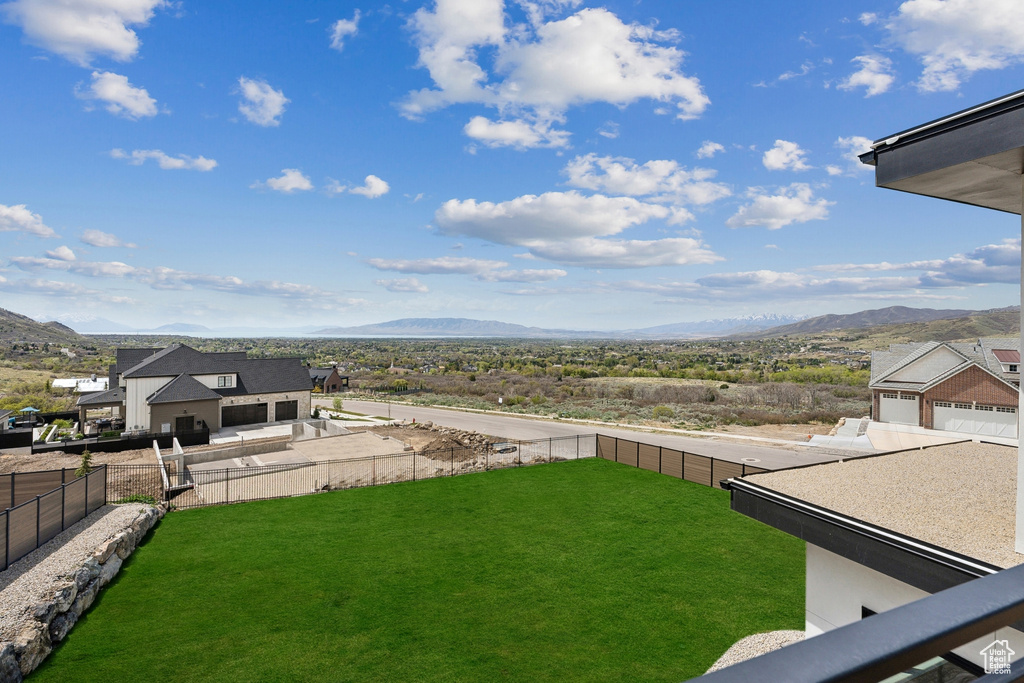 View of yard with a mountain view and fence