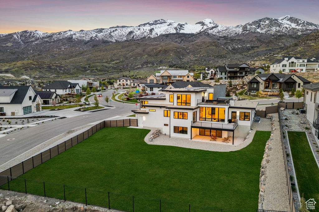 Back of property featuring stucco siding, a fenced backyard, a mountain view, and a residential view