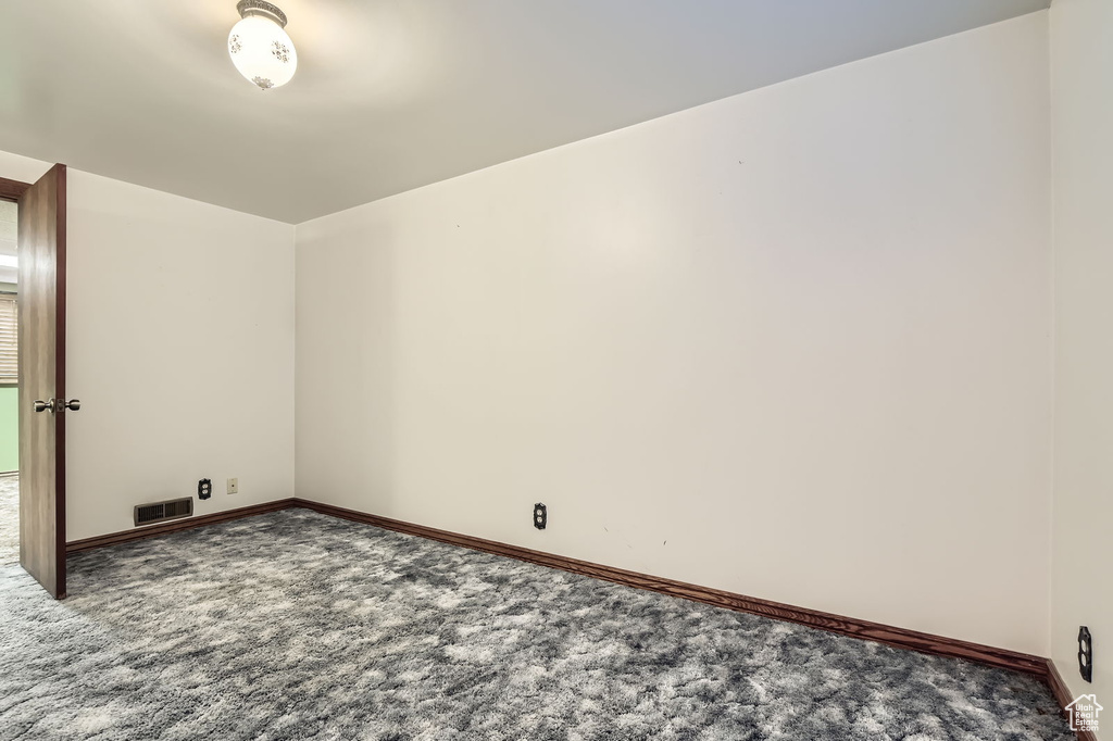 Carpeted spare room with baseboards and visible vents
