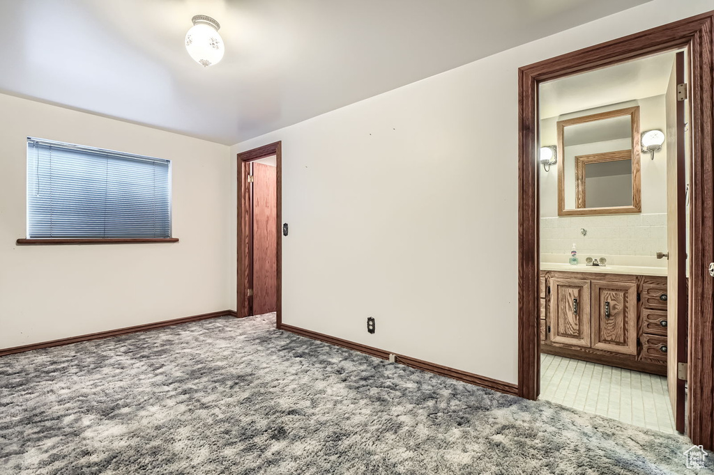 Unfurnished room featuring baseboards and light carpet
