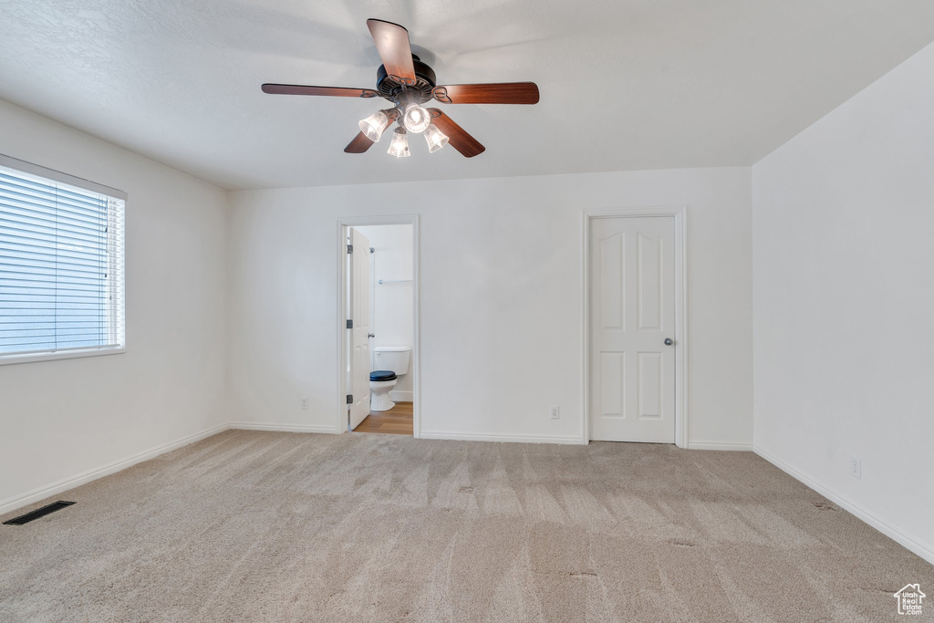 Spare room with visible vents, a ceiling fan, baseboards, and carpet flooring