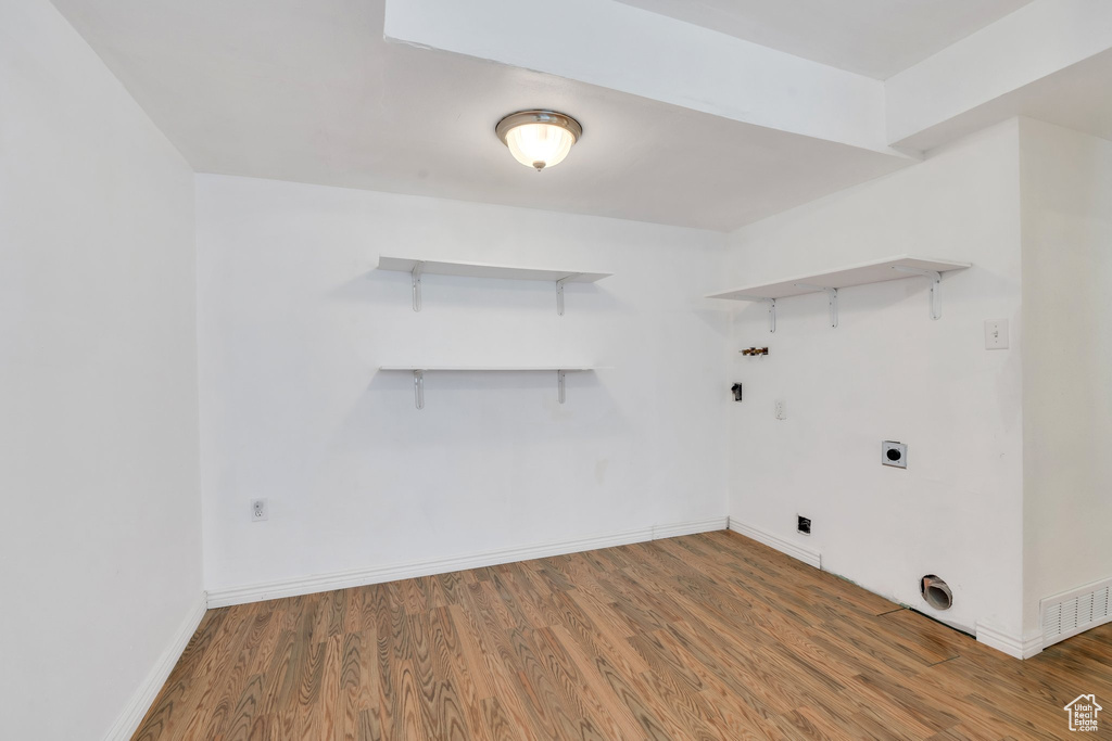 Laundry room featuring laundry area, baseboards, washer hookup, and wood finished floors