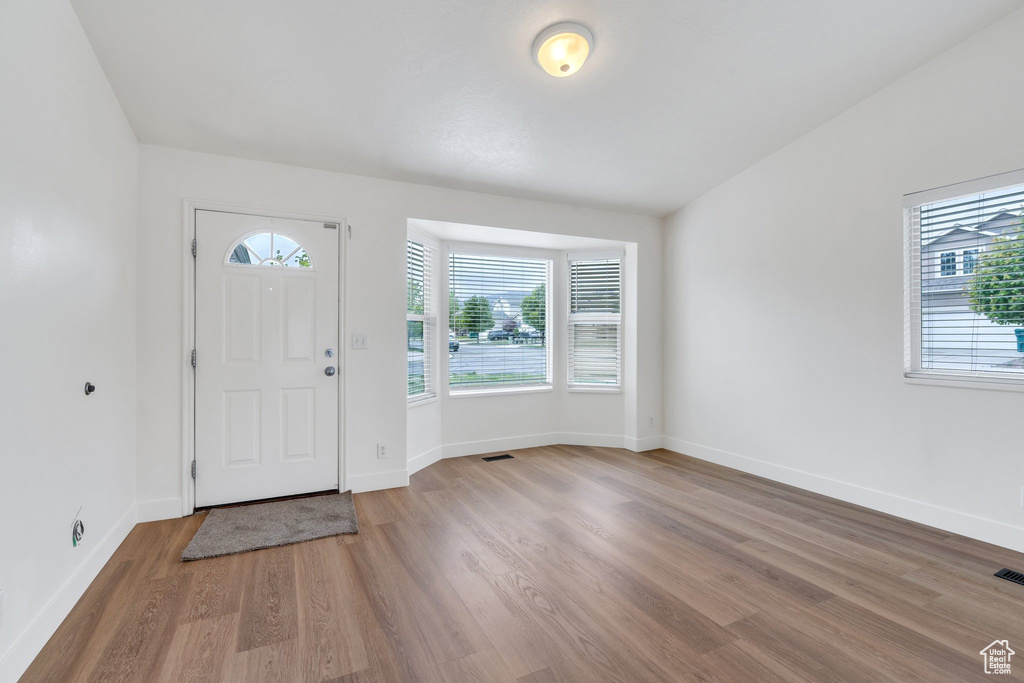 Entryway featuring baseboards, plenty of natural light, and light wood-type flooring