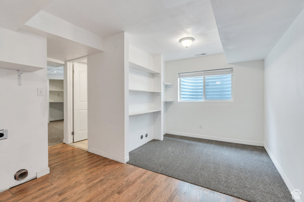 Spare room featuring baseboards, visible vents, and wood finished floors