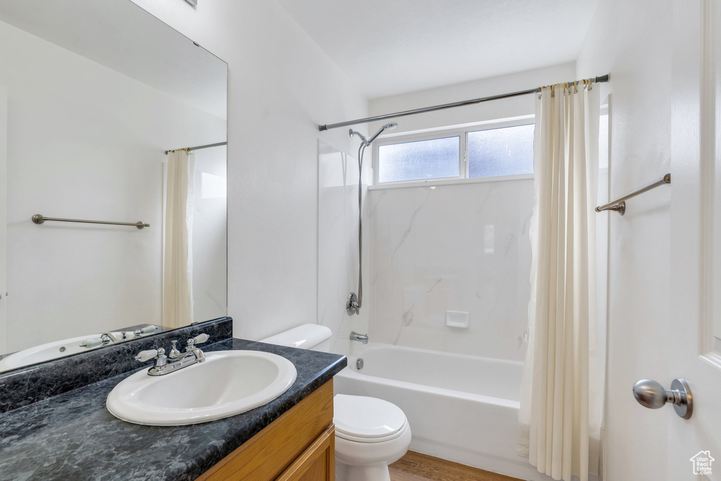 Full bathroom featuring vanity, toilet, and shower / tub combo with curtain