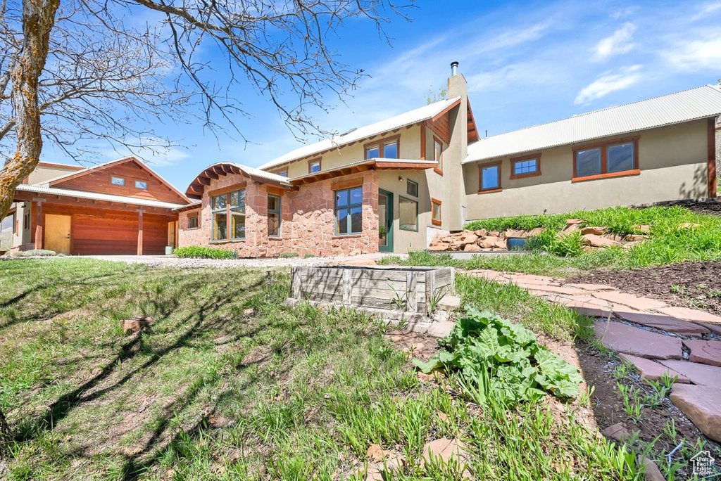 View of front of house featuring an attached garage and a chimney