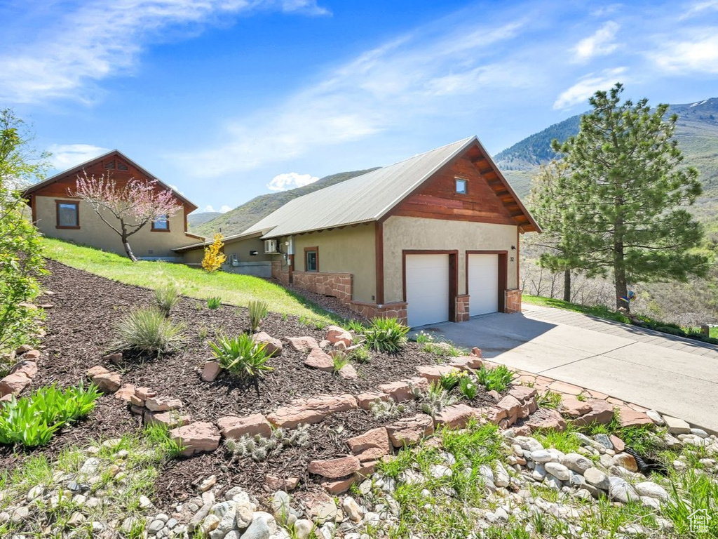 View of home\\\\\\\\\\\\\\\\\\\\\\\\\\\\\\\'s exterior featuring a detached garage, a mountain view, stone siding, and stucco siding