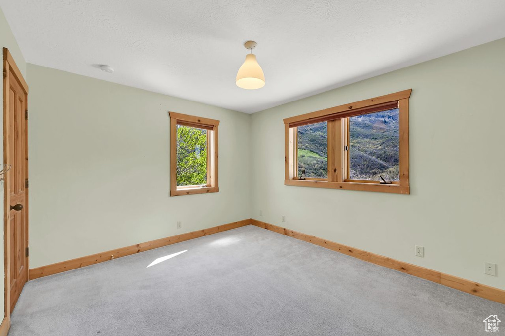 Carpeted spare room with baseboards