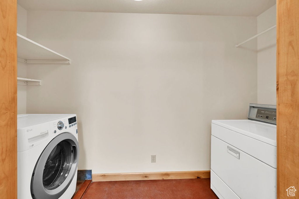 Laundry room with laundry area, baseboards, carpet, and washing machine and dryer