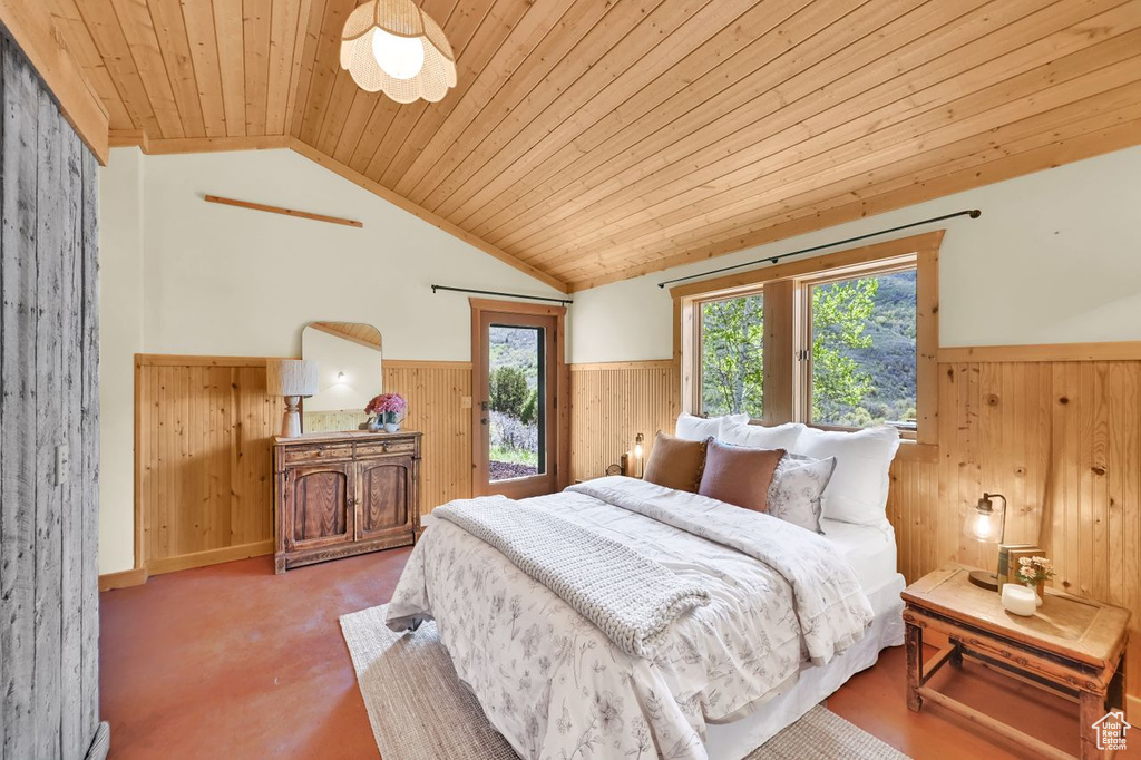 Bedroom with wooden walls, vaulted ceiling, wainscoting, and wood ceiling