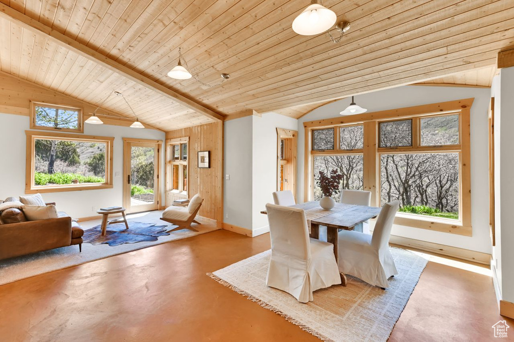 Dining space with wooden ceiling, baseboards, vaulted ceiling, and concrete floors