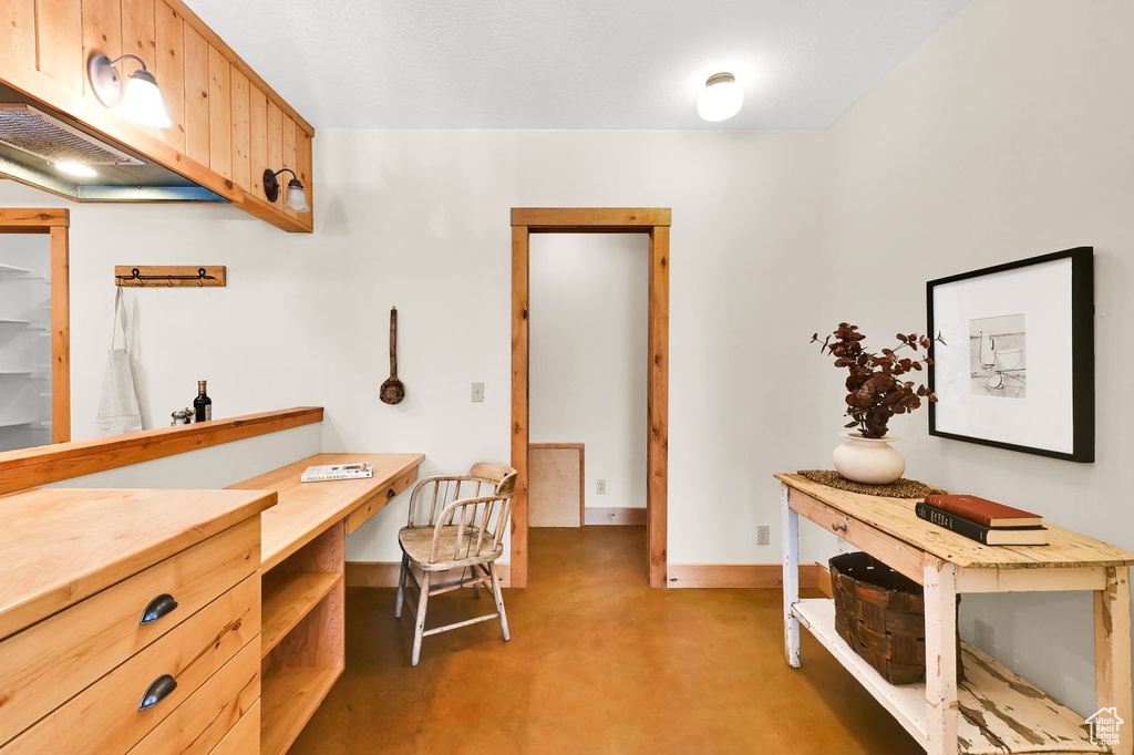 Office area featuring baseboards and finished concrete floors