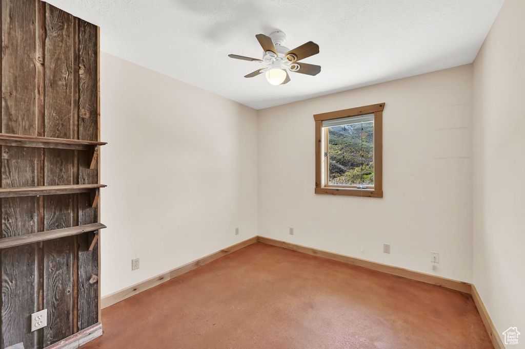 Empty room with carpet flooring, ceiling fan, and baseboards