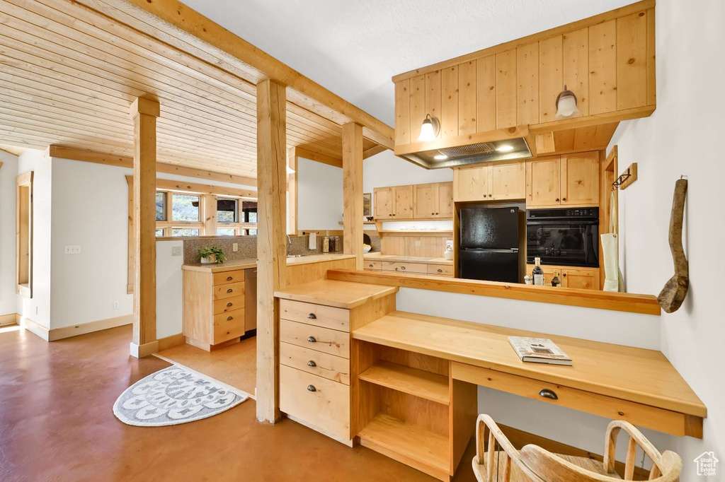 Kitchen featuring light brown cabinetry, baseboards, light countertops, finished concrete floors, and black appliances