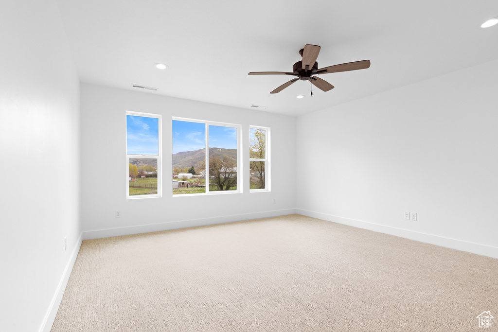Unfurnished room with a ceiling fan, visible vents, baseboards, light carpet, and recessed lighting
