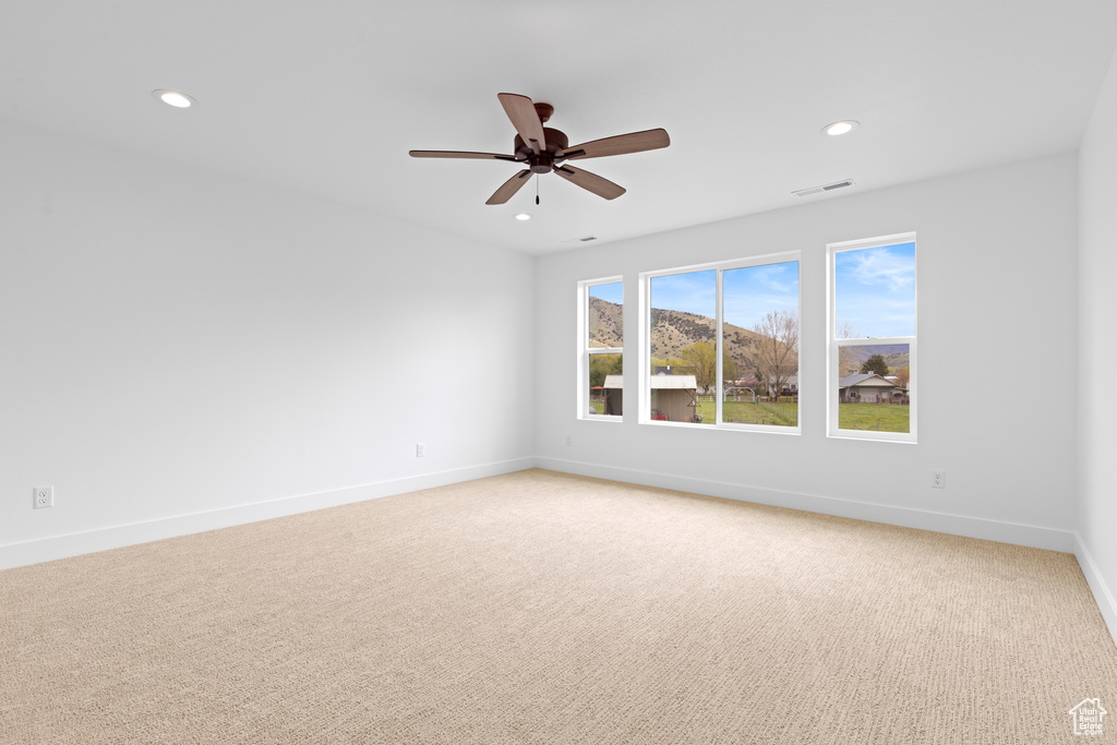 Spare room with recessed lighting, a ceiling fan, baseboards, and light carpet
