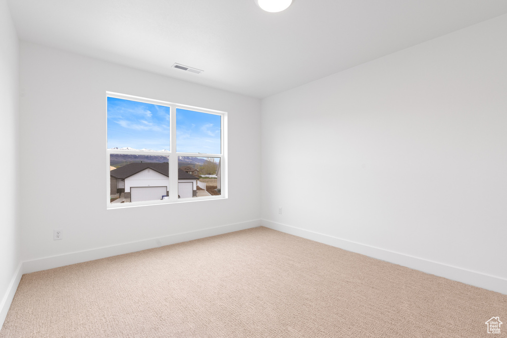 Unfurnished room featuring baseboards, carpet, and visible vents