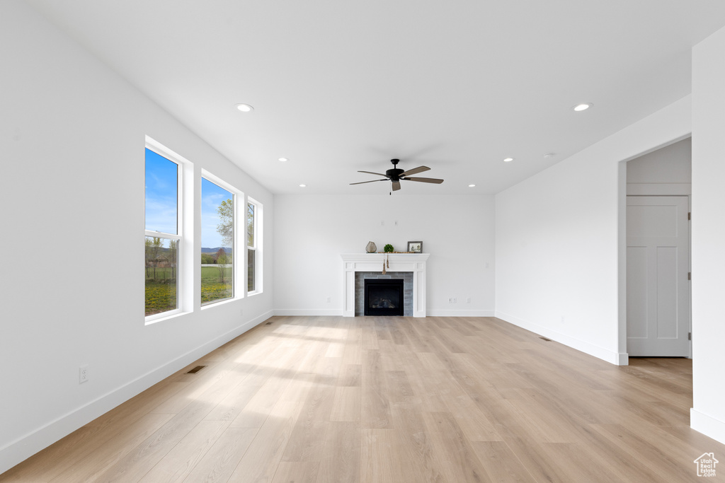 Unfurnished living room with recessed lighting, baseboards, ceiling fan, and light wood-type flooring