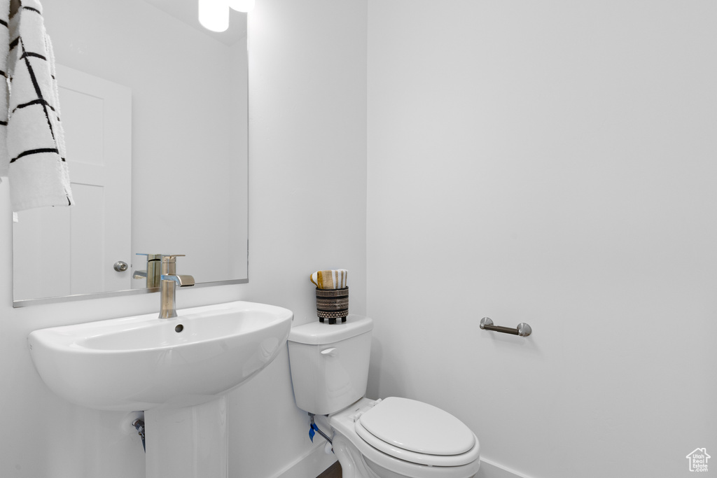 Bathroom with baseboards, a sink, and toilet