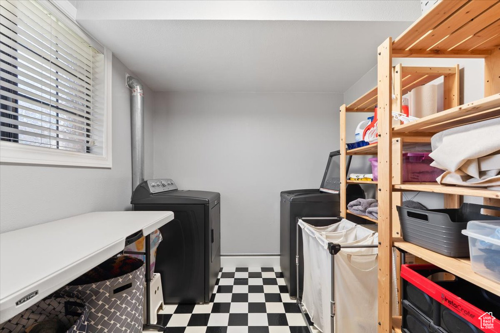 Laundry room featuring tile patterned floors, laundry area, and washing machine and clothes dryer