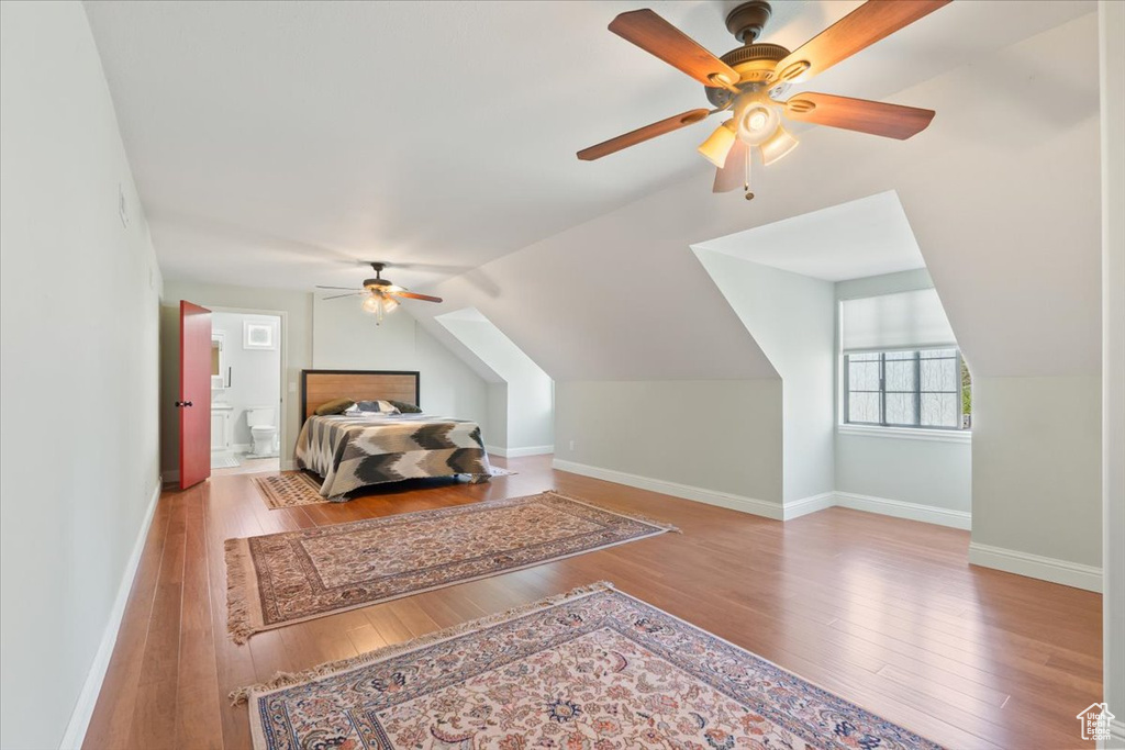 Bedroom with baseboards, a ceiling fan, vaulted ceiling, and hardwood / wood-style floors