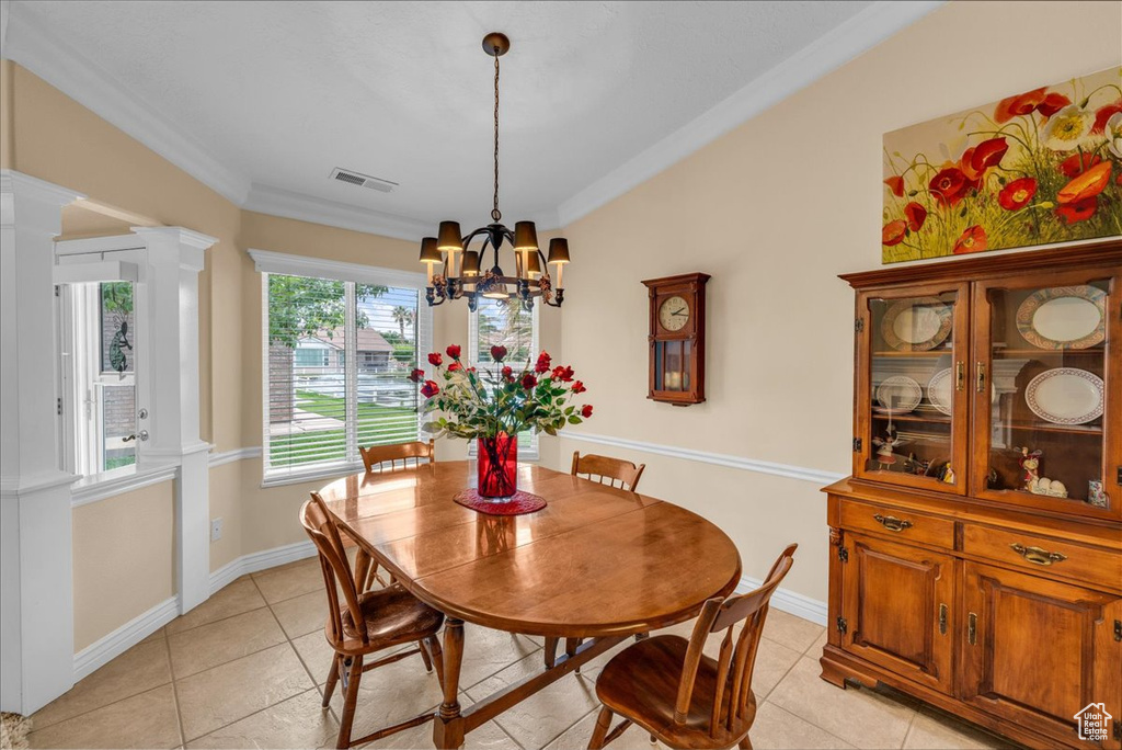 Dining room featuring crown molding, a chandelier, visible vents, and light tile patterned floors