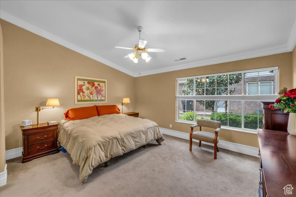 Bedroom with baseboards, vaulted ceiling, light colored carpet, and visible vents