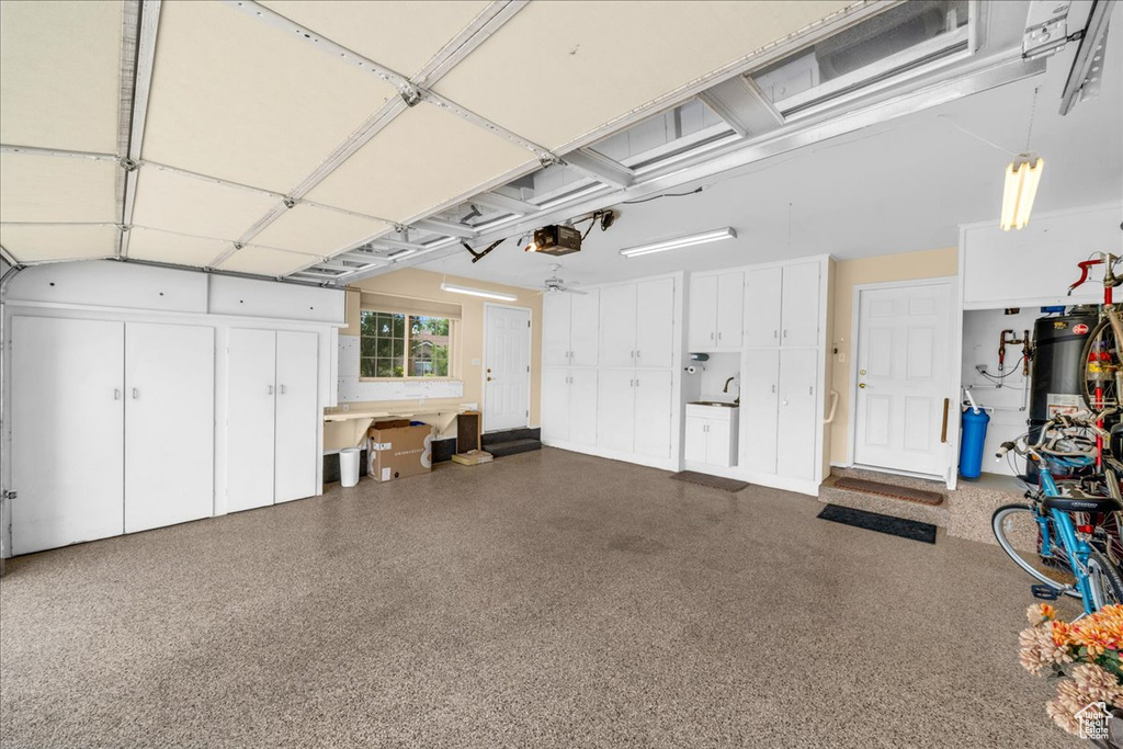 Garage featuring a garage door opener and water heater
