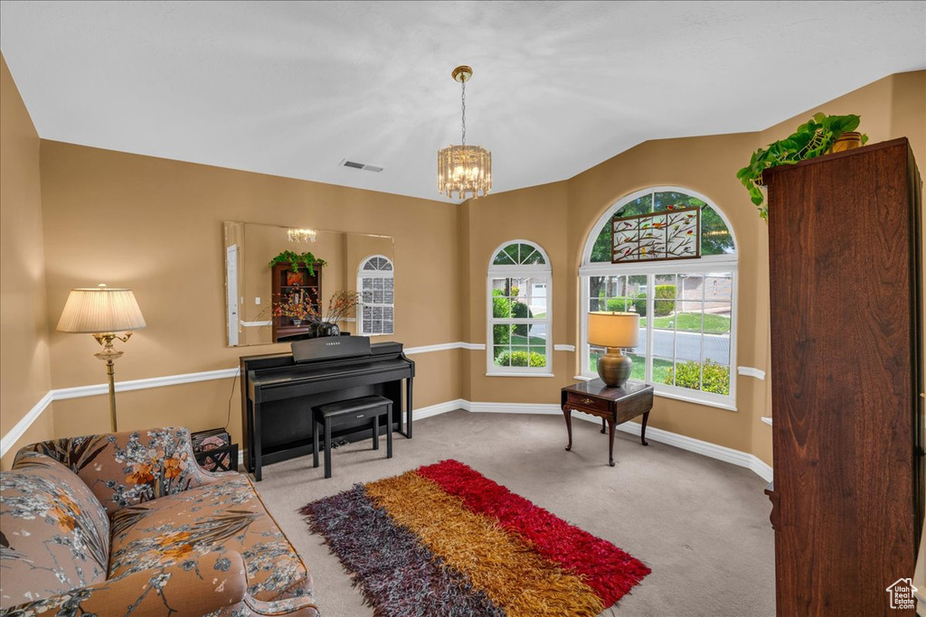 Living area featuring baseboards, visible vents, carpet flooring, and a notable chandelier