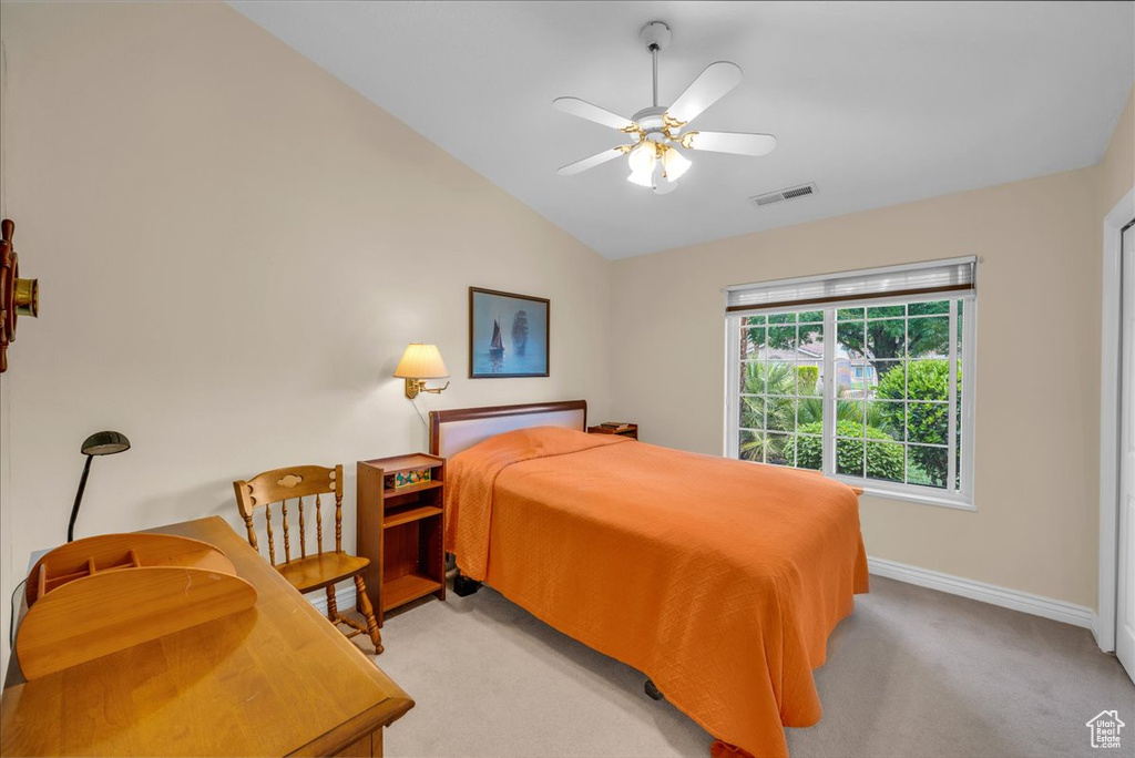 Bedroom featuring light carpet, a ceiling fan, baseboards, lofted ceiling, and visible vents