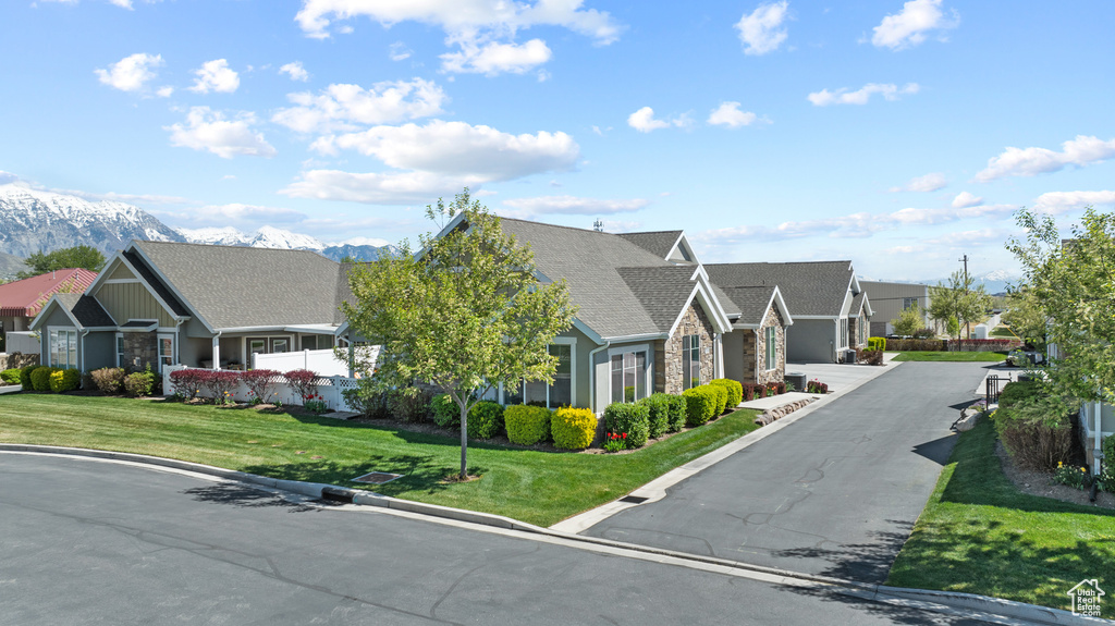 View of front of property featuring a mountain view, a front yard, and a residential view