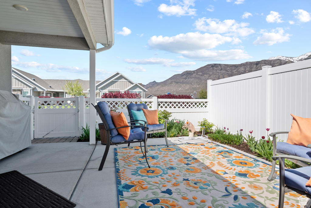 View of patio with a gate, a mountain view, and a fenced backyard