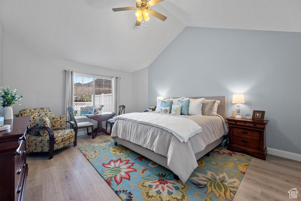 Bedroom with a ceiling fan, baseboards, wood finished floors, and lofted ceiling