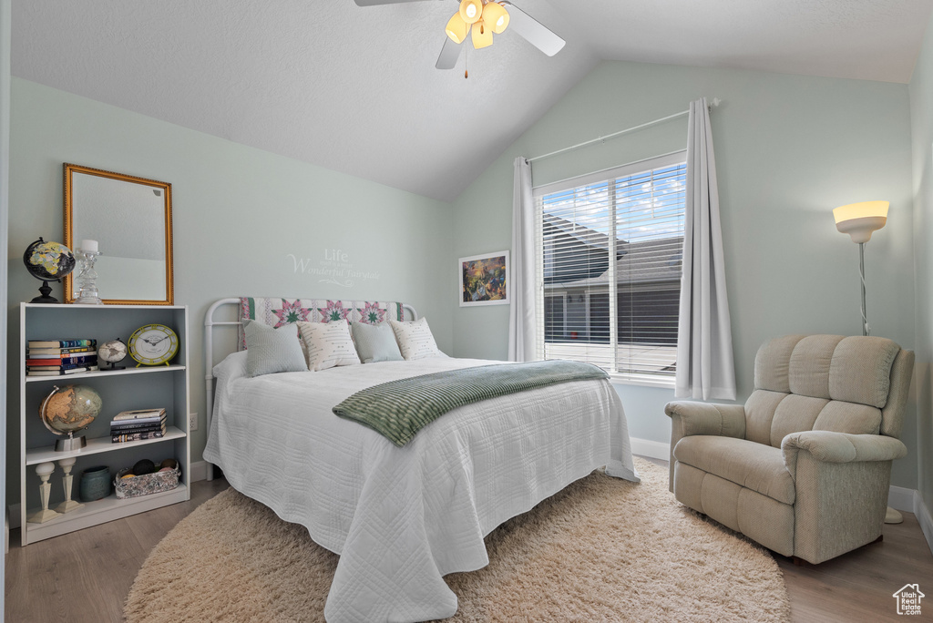 Bedroom featuring baseboards, ceiling fan, vaulted ceiling, and wood finished floors