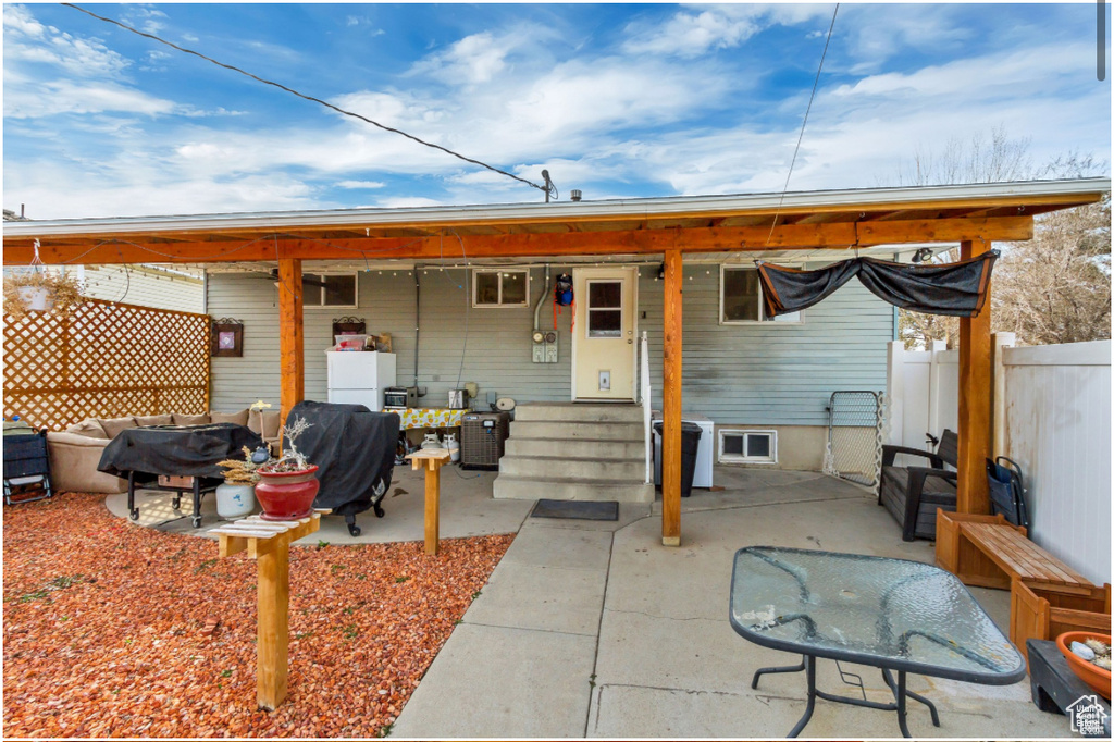 Rear view of property with a patio area and fence