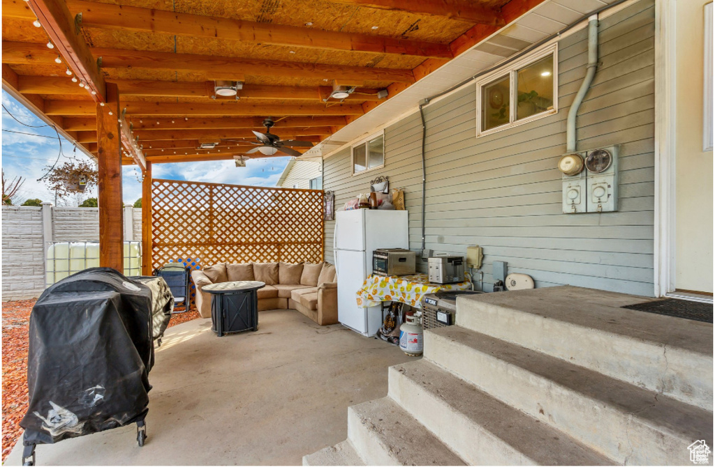 View of patio with fence, area for grilling, and outdoor lounge area