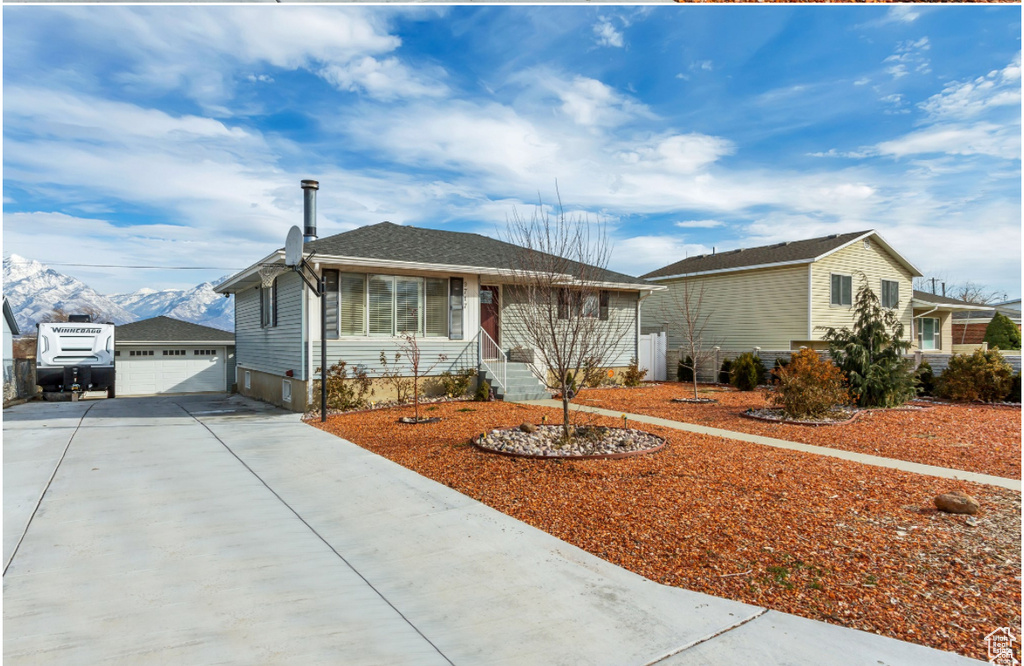 Ranch-style house featuring driveway, an outdoor structure, and a garage