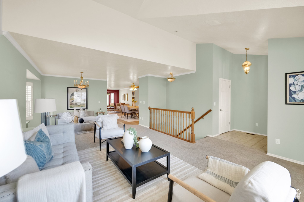 Living room with crown molding, light colored carpet, an inviting chandelier, and a wealth of natural light