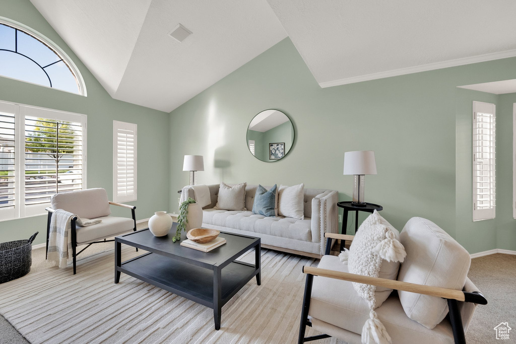 Living area featuring baseboards, vaulted ceiling, light carpet, and visible vents