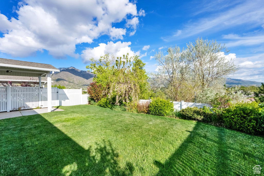 View of yard with a mountain view and fence
