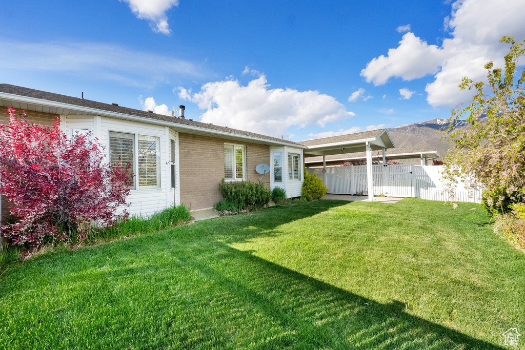 Exterior space with fence, a yard, and brick siding