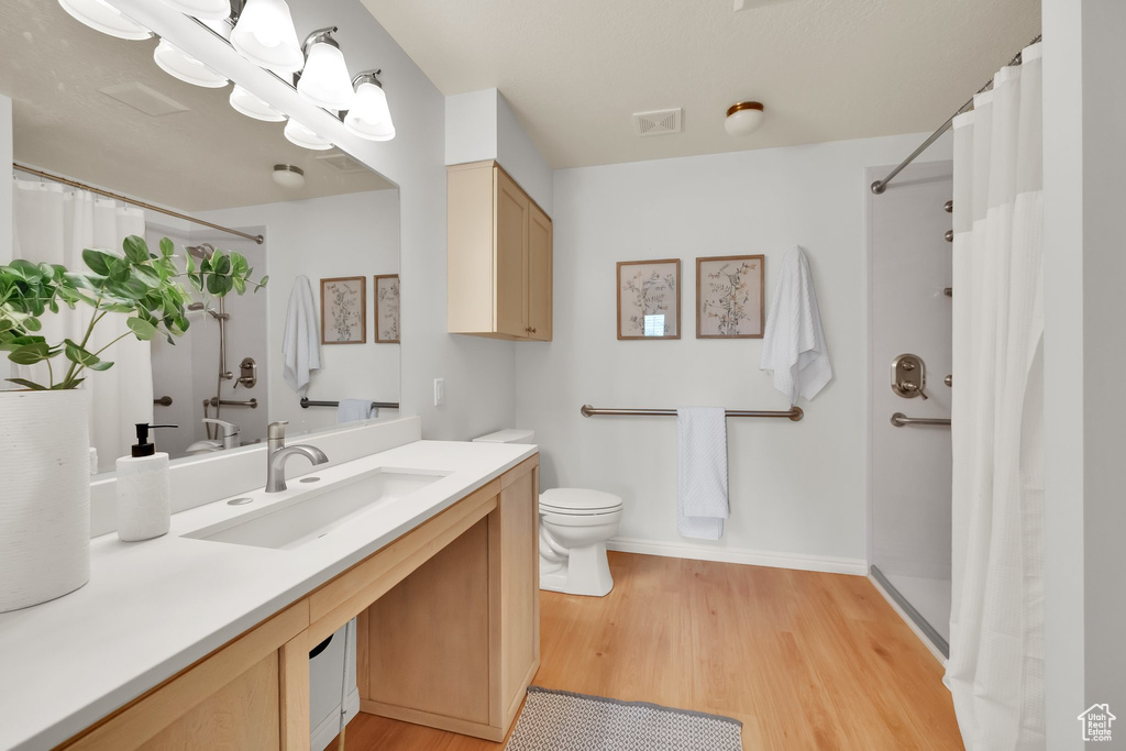 Full bath featuring visible vents, wood finished floors, vanity, toilet, and a shower with shower curtain