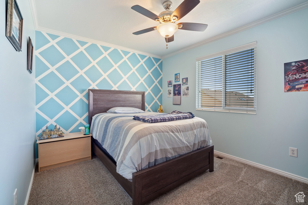 Bedroom with ornamental molding, a ceiling fan, carpet, and baseboards