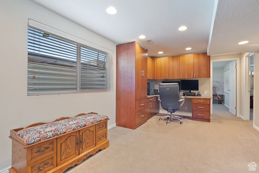 Home office with recessed lighting, built in study area, baseboards, and light colored carpet