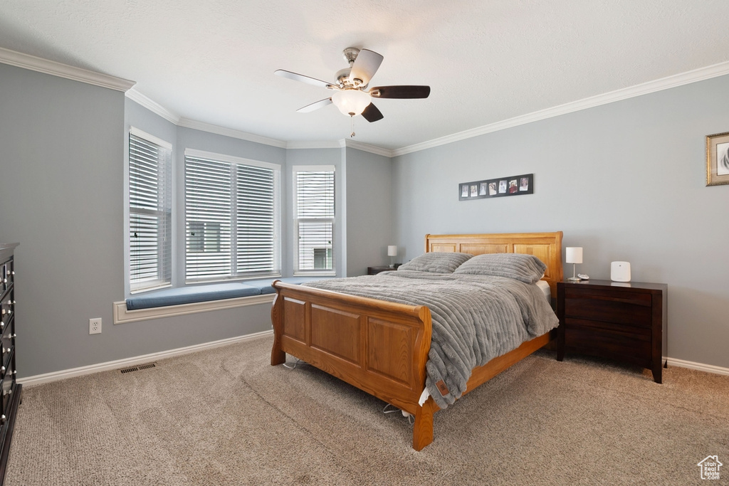 Bedroom featuring carpet floors, visible vents, baseboards, and ornamental molding