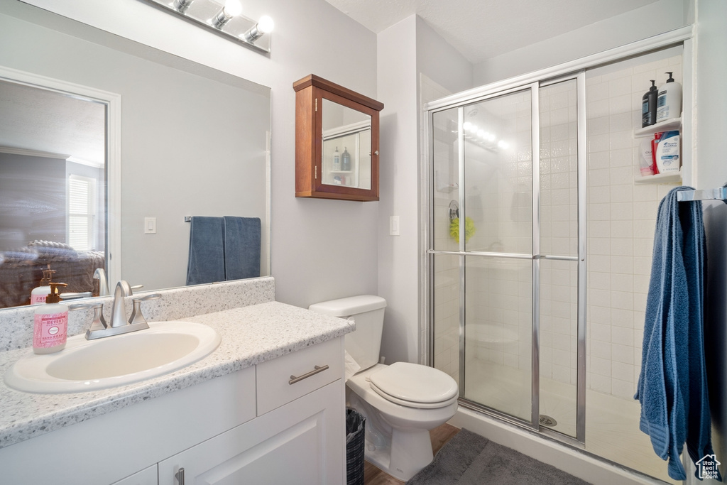Full bath with toilet, a shower stall, and vanity