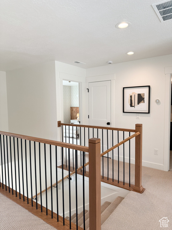 Hall featuring visible vents, baseboards, an upstairs landing, carpet flooring, and recessed lighting